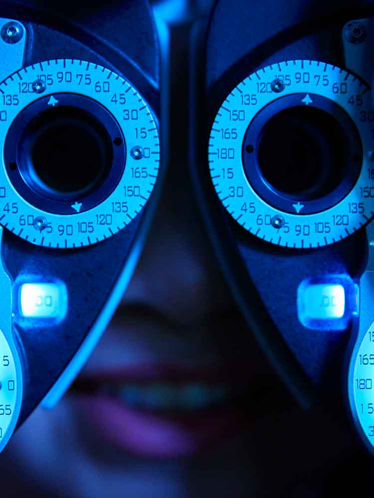 eye care patient looking through eye diagnostic tester