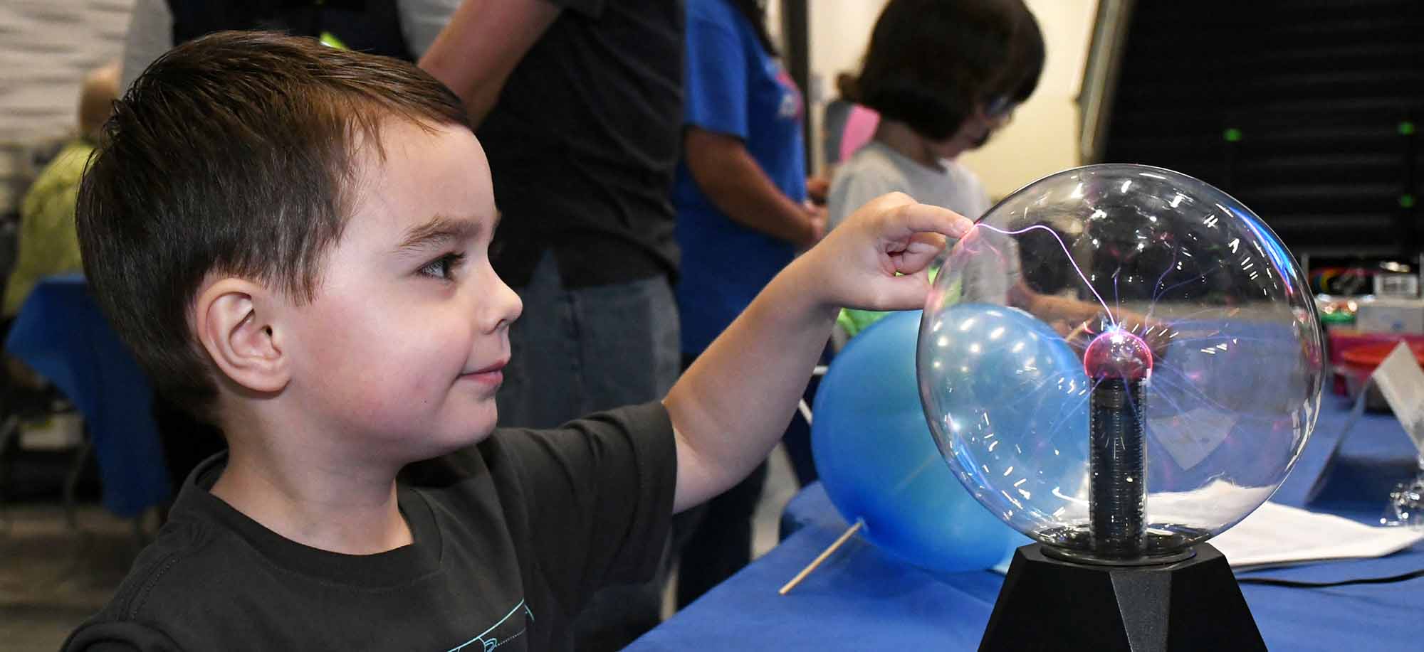 Male Child at Mind Trekkers Event Touching a Plasma Ball Lamp